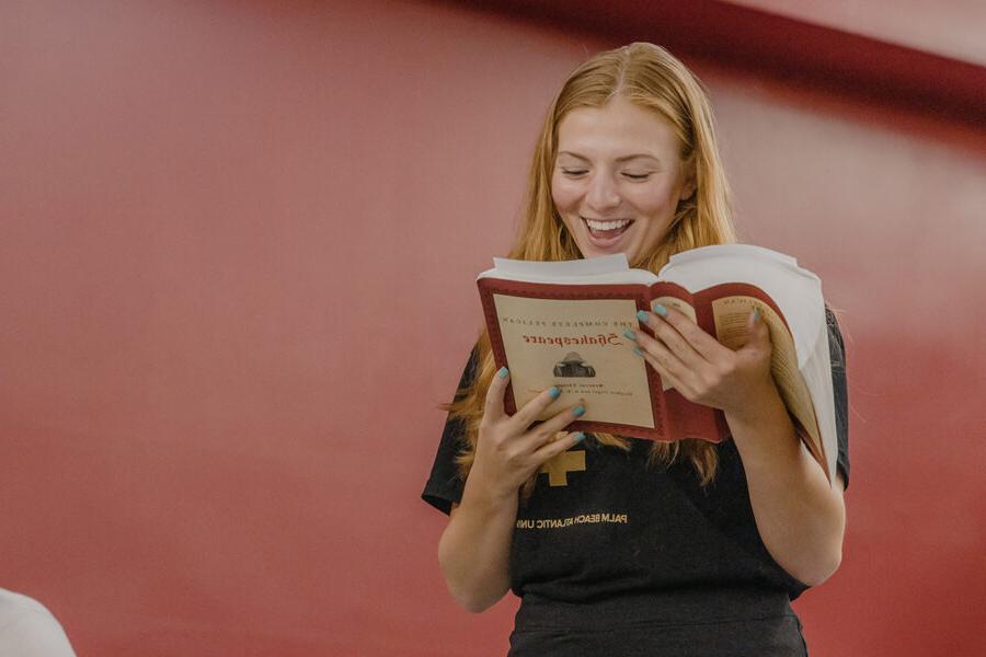 A student reading a book and smiling